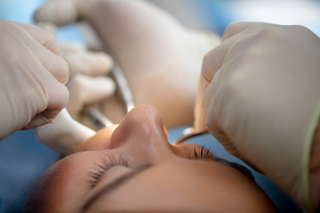 patient undergoing tooth extraction procedure before receiving oral surgery post operative instructions at Associated Oral & Implant Surgeons