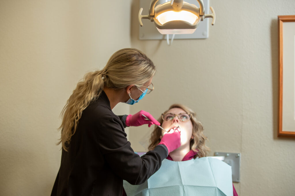 patient in dental chair with dental assistant determining if emergency dental care is required at Associated Oral & Implant Surgeons
