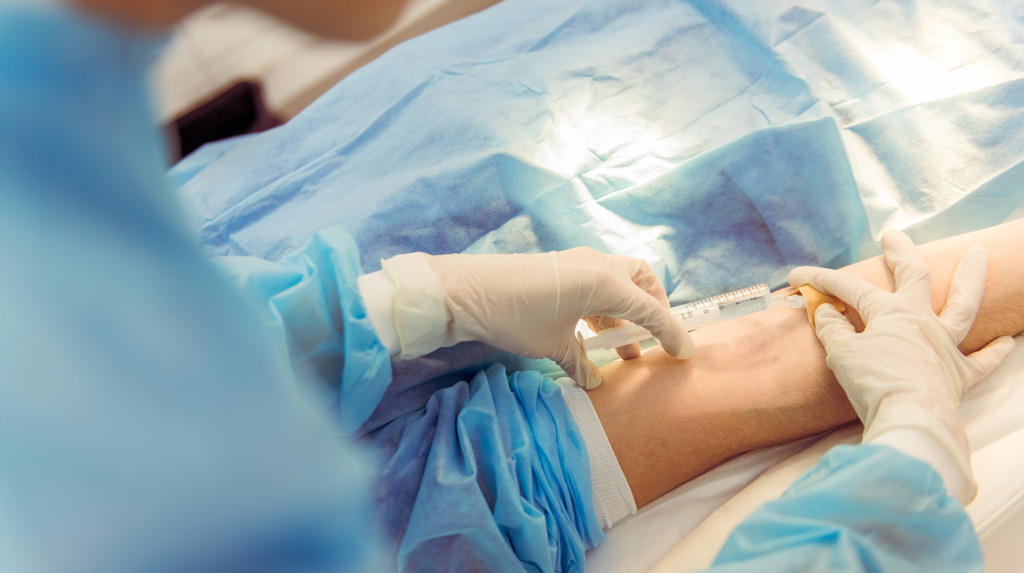 patient receiving an injection while wearing protective coverings for infection control